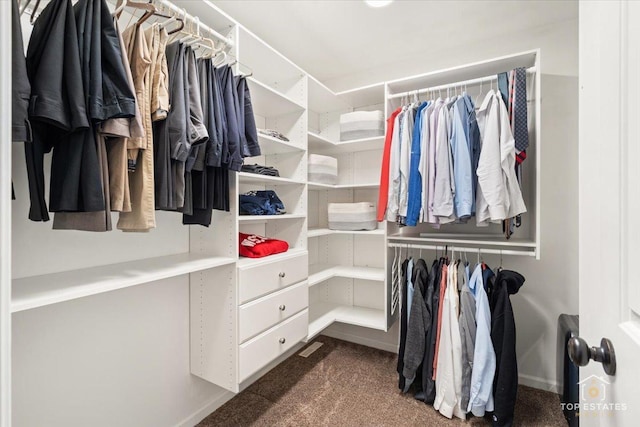 spacious closet featuring dark colored carpet