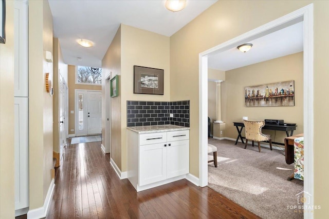 corridor with dark wood-type flooring and baseboards