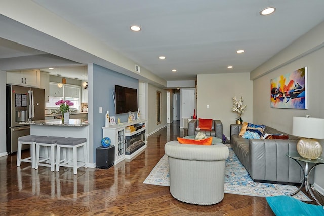 living area featuring dark wood-style floors, baseboards, and recessed lighting