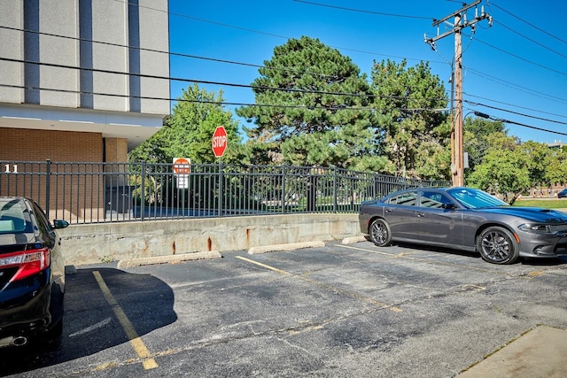 uncovered parking lot featuring fence