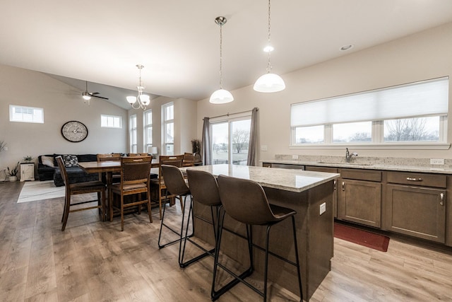 1125 Juniper Dr, Sycamore, IL 60178 - kitchen featuring a sink, a center island, vaulted ceiling, open floor plan, and light wood finished floors