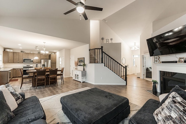 1125 Juniper Dr, Sycamore, IL 60178 - living area with a chandelier, high vaulted ceiling, stairs, wood finished floors, and ceiling fan