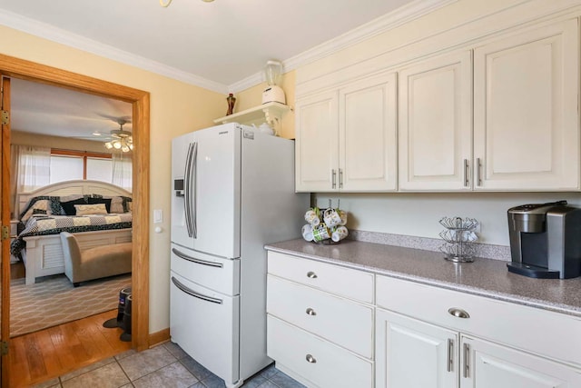 2115 N Woodlawn Park Ave, Mchenry, IL 60051 - kitchen with crown molding, white cabinetry, white fridge with ice dispenser, and a ceiling fan