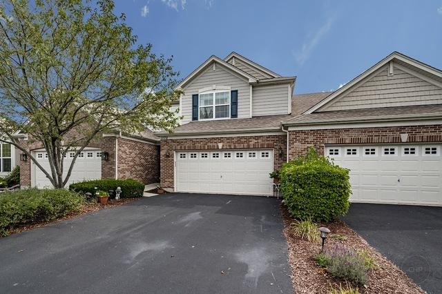 view of front facade featuring aphalt driveway, brick siding, and an attached garage