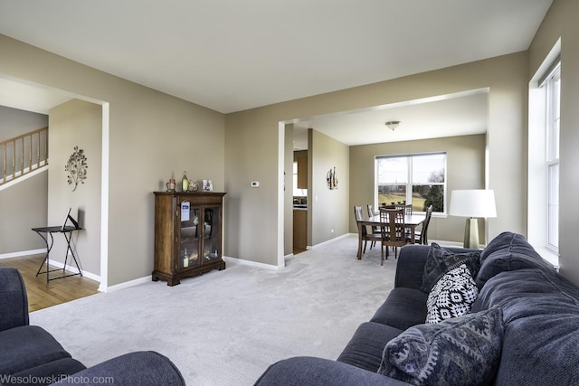 living room featuring light carpet and baseboards