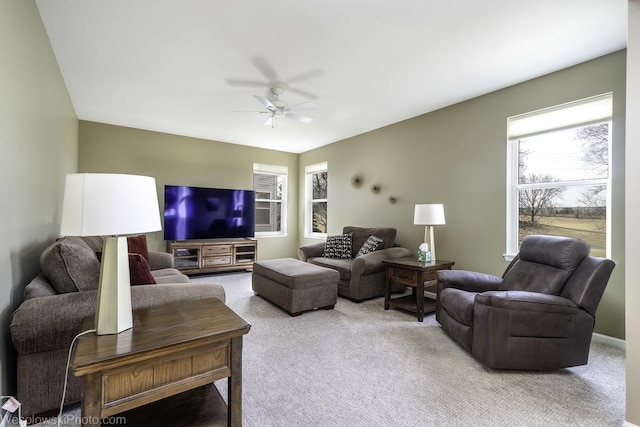 carpeted living area with a ceiling fan