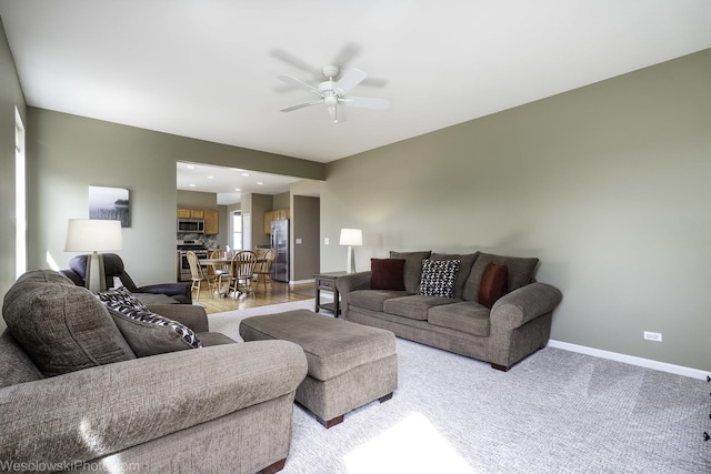 living room with a ceiling fan and baseboards