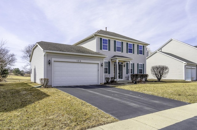 colonial inspired home with driveway, a front lawn, a garage, and a shingled roof