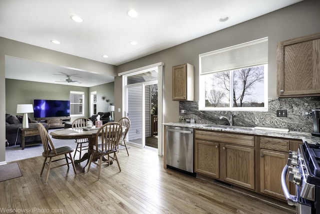 kitchen featuring a healthy amount of sunlight, light wood-type flooring, appliances with stainless steel finishes, and a sink