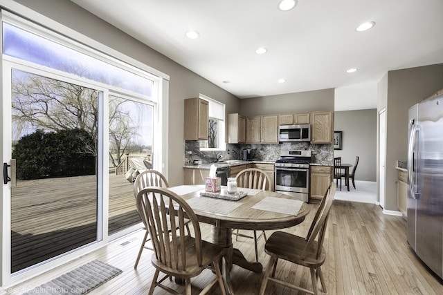 dining area featuring light wood finished floors, recessed lighting, and baseboards