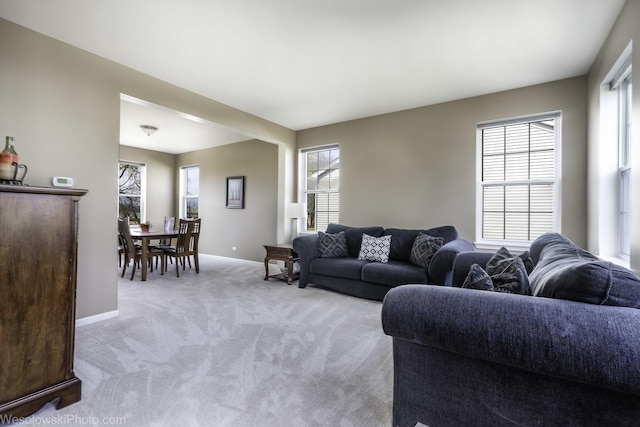 living room featuring light carpet and baseboards