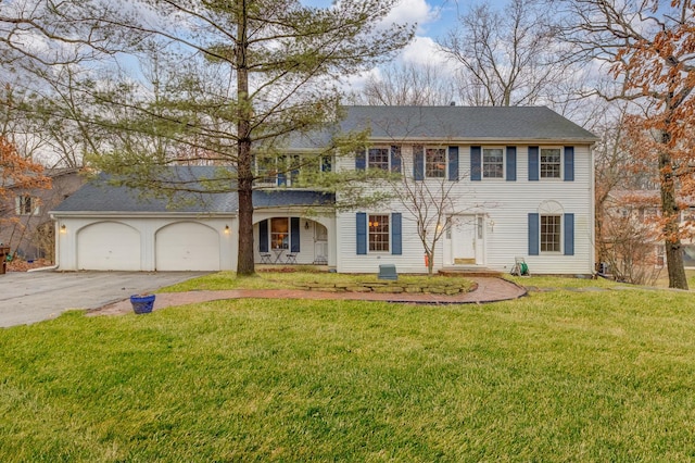 colonial-style house with an attached garage, a front lawn, and aphalt driveway