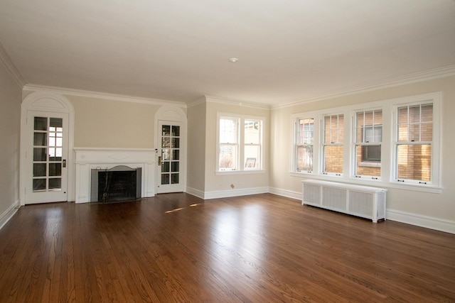 unfurnished living room featuring dark wood-style floors, radiator, a fireplace, and crown molding