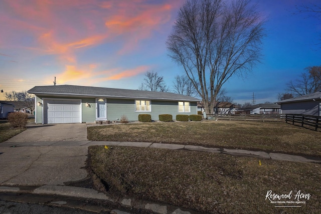 ranch-style house featuring driveway, an attached garage, fence, and a front yard