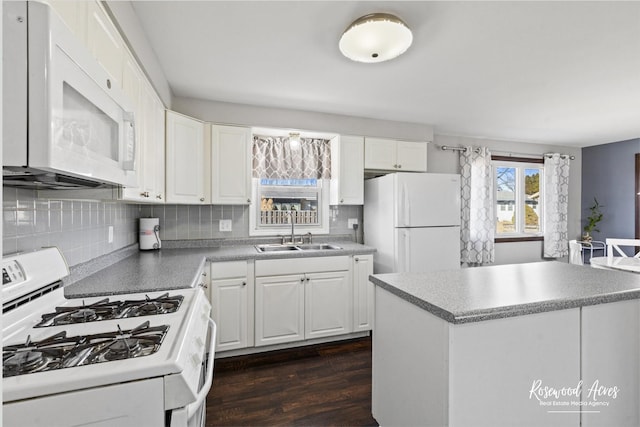 kitchen featuring white appliances, a sink, white cabinetry, tasteful backsplash, and dark wood finished floors