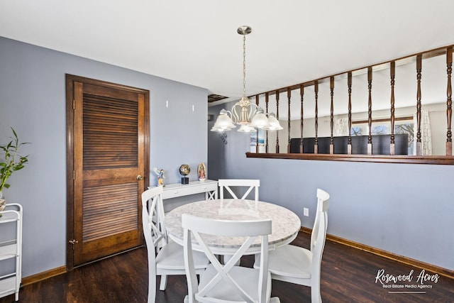 dining space featuring baseboards, wood finished floors, and a notable chandelier