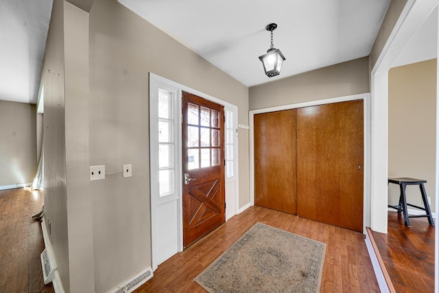 foyer featuring wood finished floors and baseboards