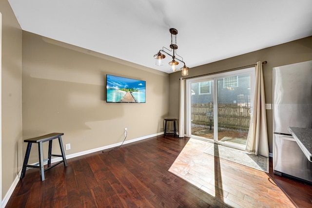 unfurnished dining area featuring baseboards and wood finished floors