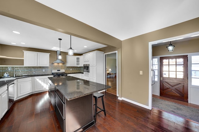 kitchen with dark wood-style flooring, open shelves, stainless steel appliances, decorative backsplash, and wall chimney range hood