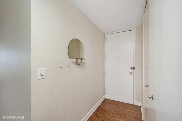 corridor with baseboards and wood finished floors