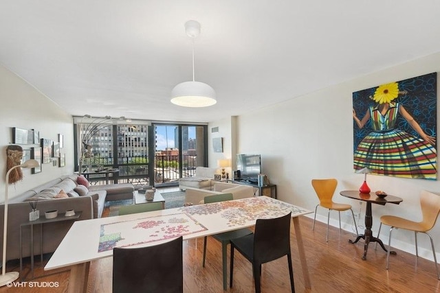 dining room with a wall of windows, baseboards, and wood finished floors