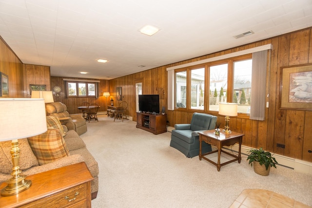 living area with wood walls, carpet, and visible vents