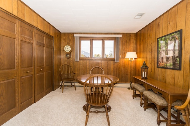 interior space with a baseboard radiator, light carpet, and wood walls