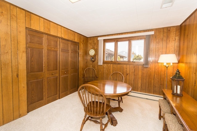 dining space featuring wooden walls, visible vents, baseboard heating, and carpet flooring