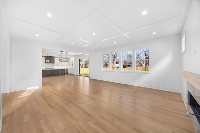 unfurnished living room featuring baseboards, coffered ceiling, light wood-style flooring, a fireplace, and recessed lighting