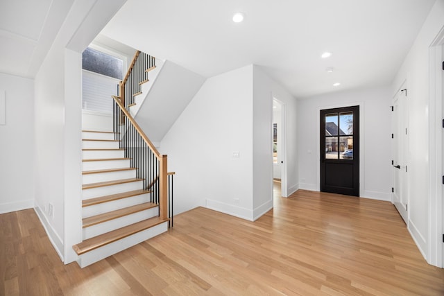 entryway with recessed lighting, light wood finished floors, and stairs