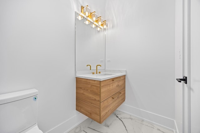 bathroom featuring toilet, marble finish floor, baseboards, and vanity