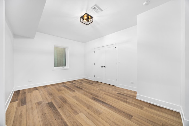 empty room with baseboards, visible vents, and wood finished floors