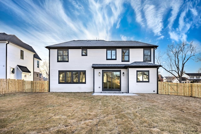 rear view of house featuring a fenced backyard, a patio, and a yard