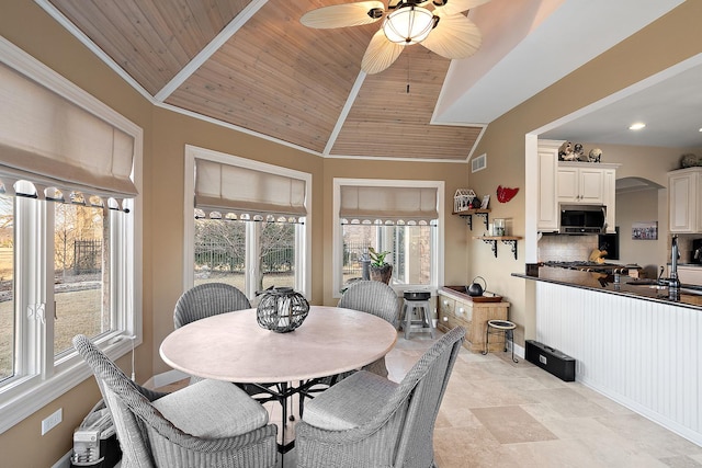 dining area featuring visible vents, baseboards, lofted ceiling, arched walkways, and wood ceiling