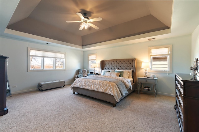 bedroom with baseboards, carpet, a tray ceiling, and a ceiling fan