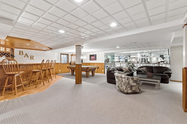 playroom featuring wooden walls, carpet flooring, wainscoting, a paneled ceiling, and a dry bar