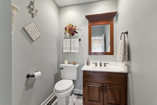 half bath with vanity, toilet, and baseboards