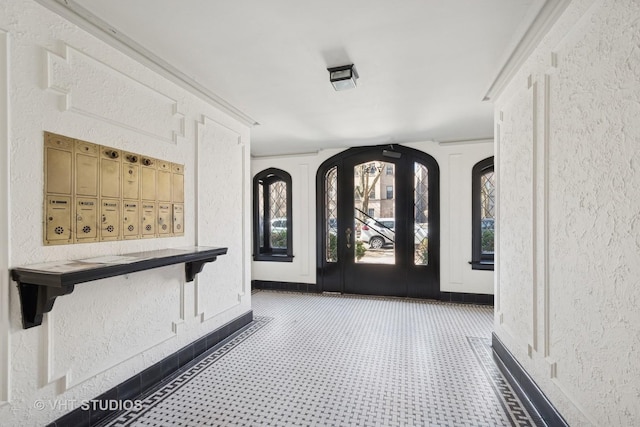 entryway featuring a textured wall and baseboards