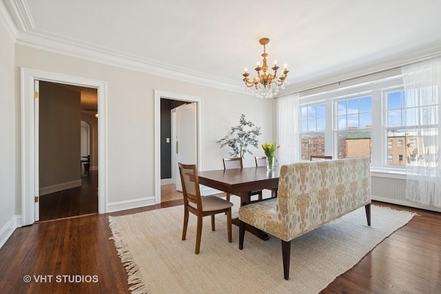 dining room with hardwood / wood-style flooring, ornamental molding, baseboards, and a chandelier