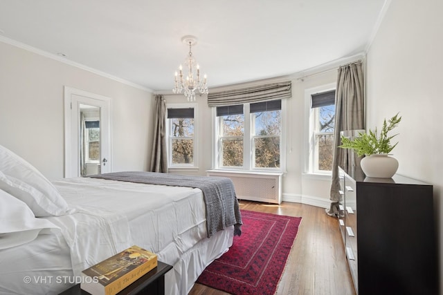 bedroom featuring crown molding, radiator heating unit, an inviting chandelier, and wood finished floors