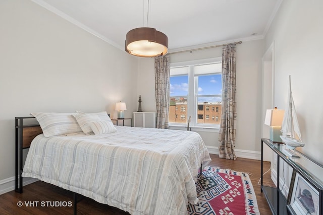 bedroom with baseboards, wood finished floors, and crown molding