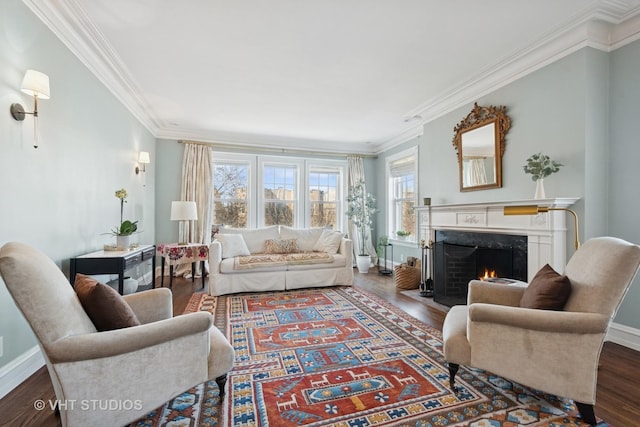 living area with wood finished floors, baseboards, a high end fireplace, and ornamental molding