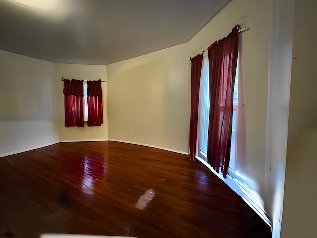 empty room featuring hardwood / wood-style floors and baseboards