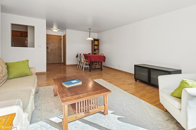 living area with baseboards and wood finished floors