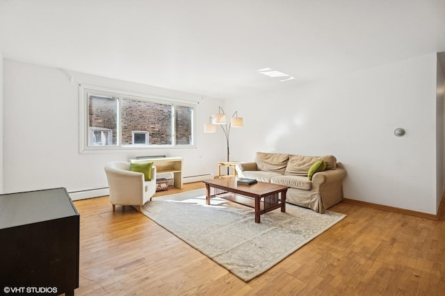 living area with light wood-style floors, baseboards, and a baseboard heating unit