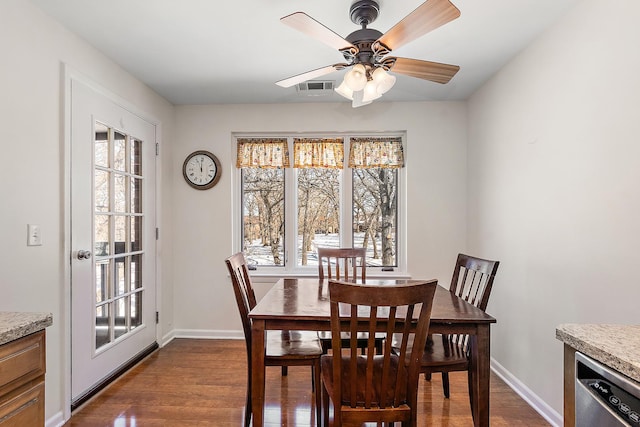 dining room with dark wood-style floors, ceiling fan, visible vents, and baseboards