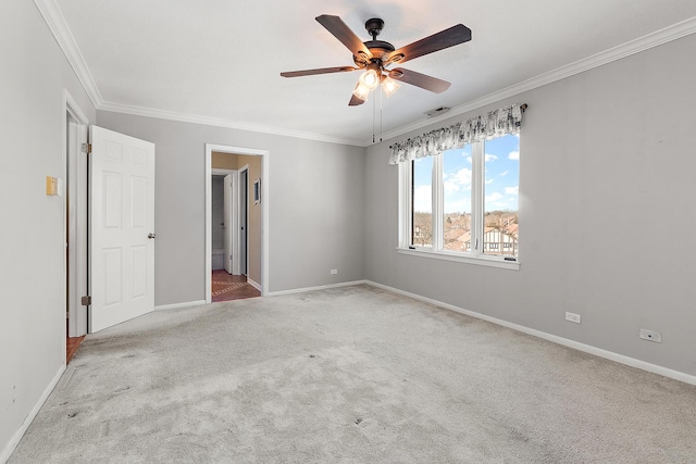 unfurnished bedroom featuring carpet floors, crown molding, visible vents, a ceiling fan, and baseboards