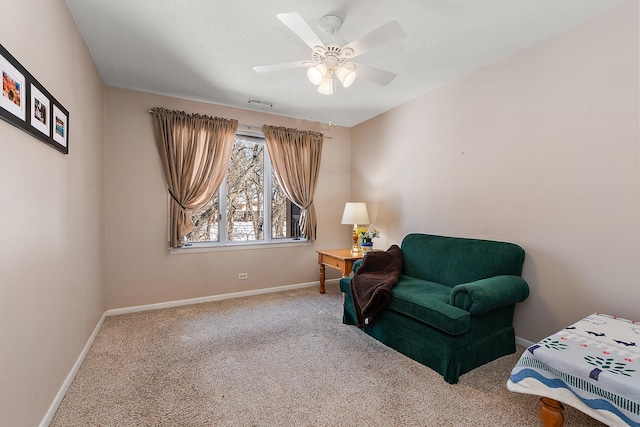 living area featuring carpet, baseboards, visible vents, and ceiling fan