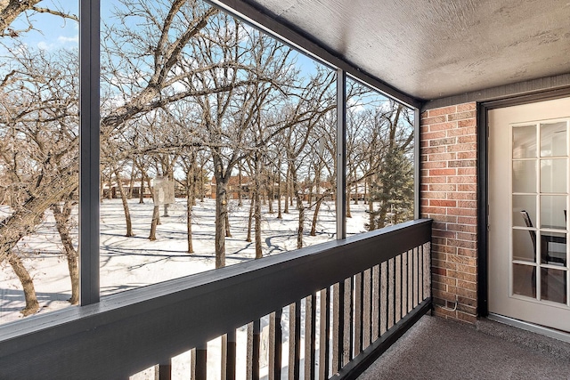 view of snow covered back of property