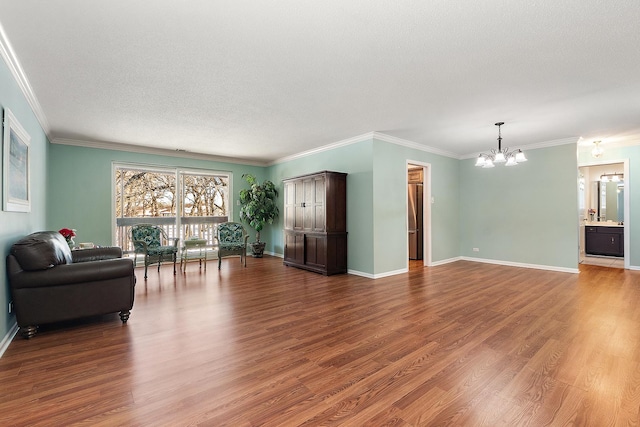 living area featuring baseboards, a textured ceiling, a chandelier, and wood finished floors